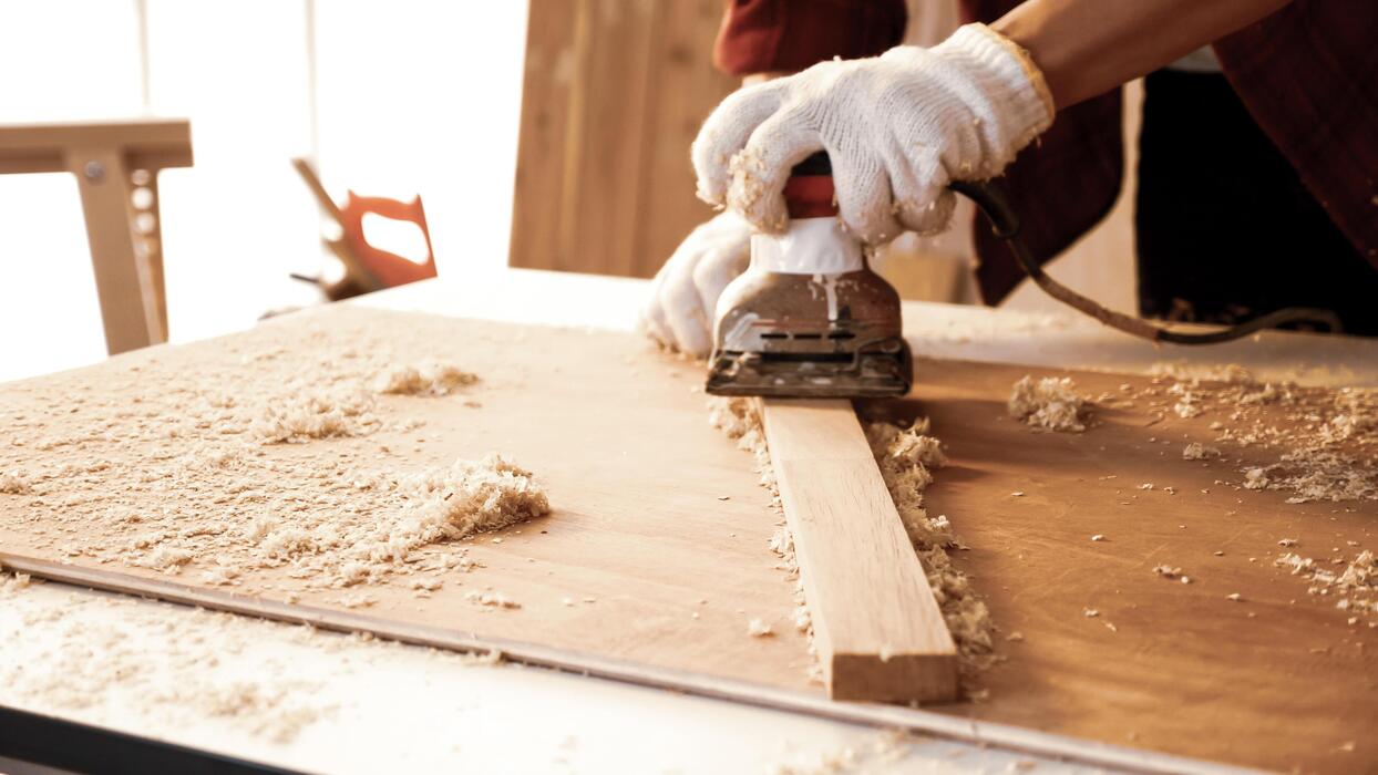 Custom carpentry — sanding a wood board